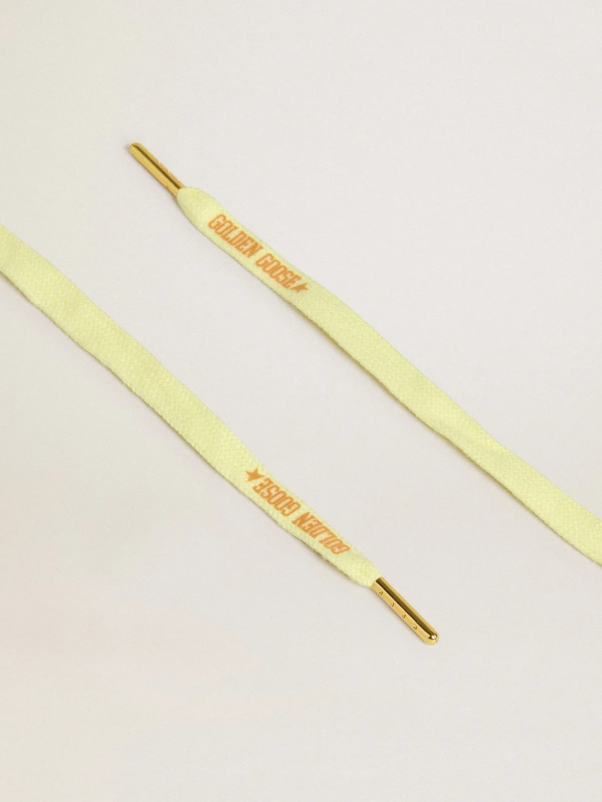 Cordones de algodón amarillo con logotipo dorado en contraste